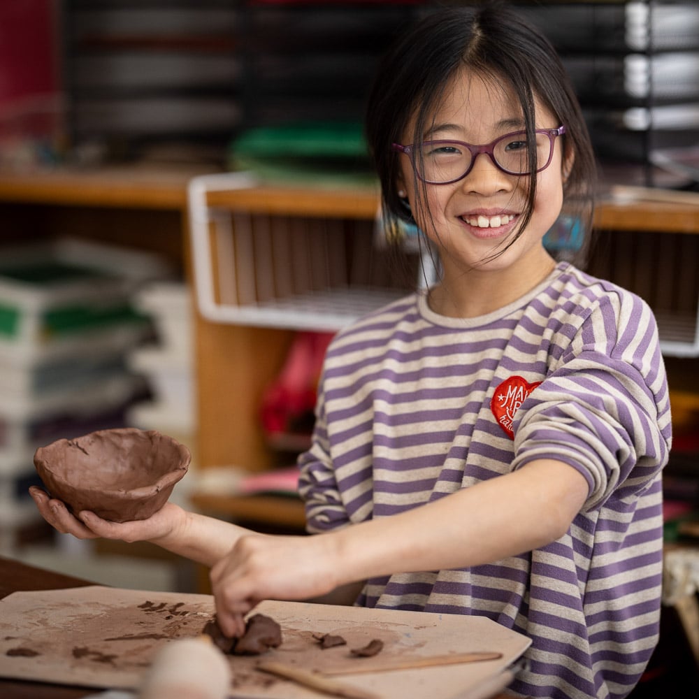 Student working with pottery